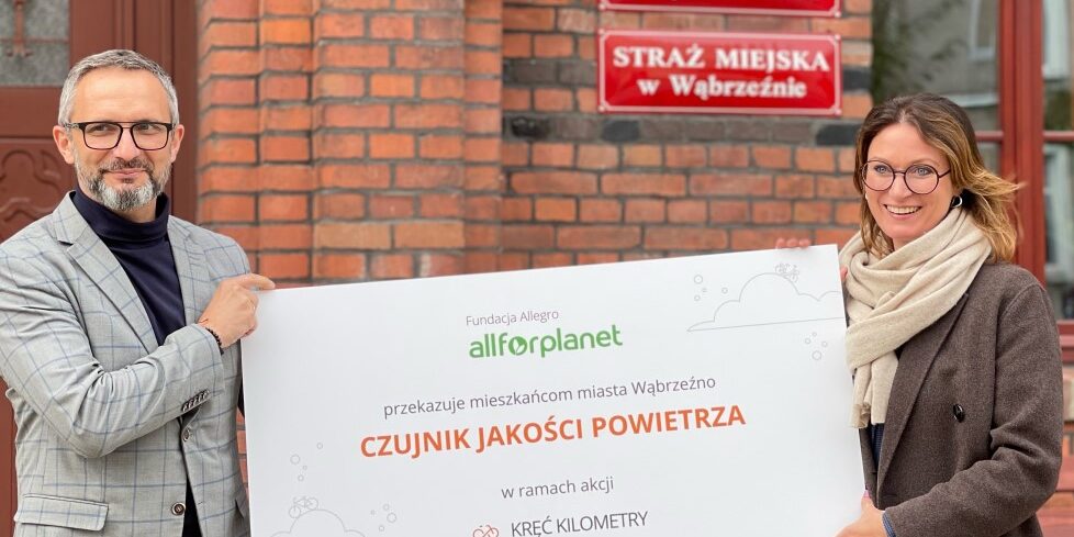 Zdjęcie osób trzymających czujnik jakości powietrza